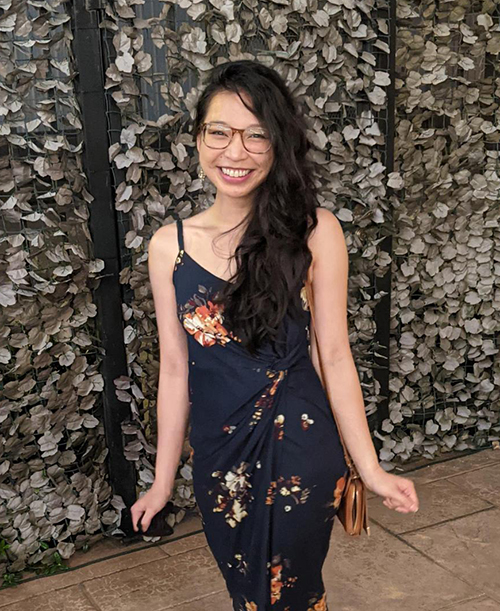 portrait of Denise Magdale smiling against a foliage background